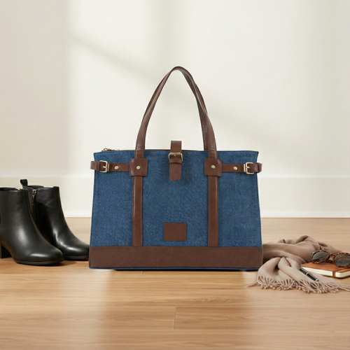 Blue denim luxury tote bag with tan leather accents and front square patch emblem